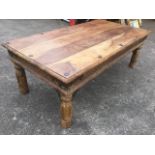 A hardwood coffee table, the rectangular top above a carved frieze with iron mounts, raised on