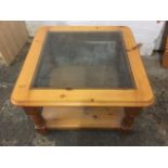 A square pine coffee table, with bevelled plate glass top in rounded moulded frame, supported on