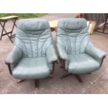 A pair of contemporary green leather adjustable armchairs, swivelling on bases with five splayed