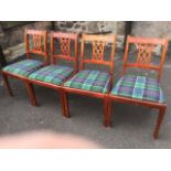 A set of four regency style dining chairs, the backs with carved pierced splats having tartan