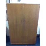 An oak wardrobe, with two plain panelled doors having brass hinges, with mirror to door interior,