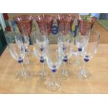 A set of nine champagne flutes on slender stems with blue bead decoration; and four large wine