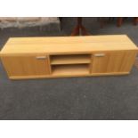 A contemporary oak cabinet, the rectangular top above a central open compartment with adjustable