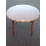 A circular dining table, the moulded top supported on angled turned legs.