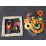 Two modern abstract art wall pieces in coloured metal, one with pierced oval forms, the other with