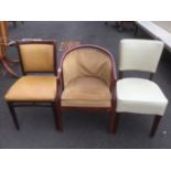An upholstered armchair with rounded back and cushion seat; a modern chair with ivory coloured