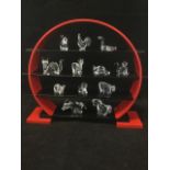 Twelve Swarovski Chinese zodiac symbols, sitting on a four tier stand, including the dog, the