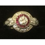 A ruby & diamond dress ring, with central brilliant cut diamond raised above circle of rubies,