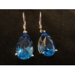 A pair of large 18ct pear shaped blue topaz drop earrings, the cut claw set stones of 22 carats on