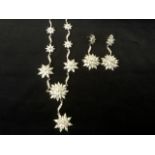 A silver & cubic zirconia necklace and earring set, with flowerhead medallions on waved bands -
