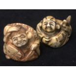 A carved ivory netsuke of a gentleman holding a fish; and another of a kimonoed man with a fish