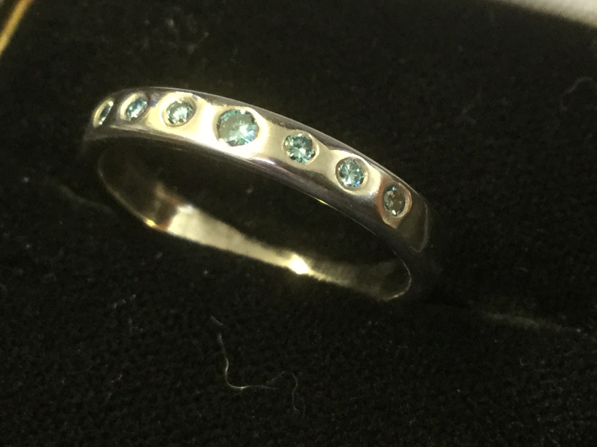 A platinum ring set with seven blue stones - untested.