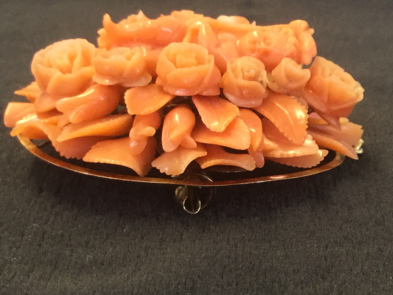 An oval carved coral brooch with cenral cherub framed by flowers and leaves, the panel mounted on - Image 2 of 3