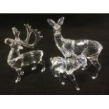 A Swarovski stag with crystal antlers & yellow stone eyes; and a doe with her fawn, each with