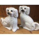 A pair of Victorian wally dogs, seated on their haunches with gilded decoration, set with amber