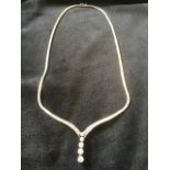 A fine diamond necklace, the snake chain mounted with a waved wishbone band set with graduated