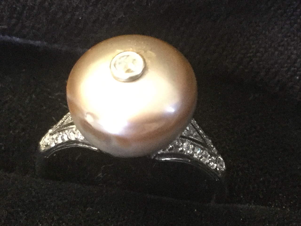 An unusual button shaped natural pearl ring, the saltwater drilled pearl mounted with single