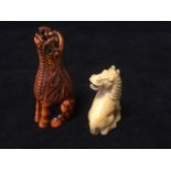 A carved ivory netsuke of a horse with turned head seated on his haunches; and a later stained
