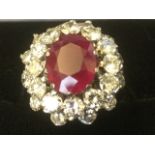 A large 18ct gold ruby & diamond ring, the oval claw set ruby of over two carats raised above two