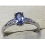 An 18ct white gold sapphire & diamond ring, the oval claw set sapphire of over half a carat,