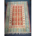 A rectangular kelim woven with madder panel of eight snowflake medallions in railwayline borders,