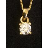 An 18ct yellow gold diamond pendant mounted on a fine gold chain, the single circular stone of a