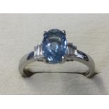An 18ct hallmarked gold aquamarine & diamond ring, the claw set oval aquamarine stone of 1.2 carats,