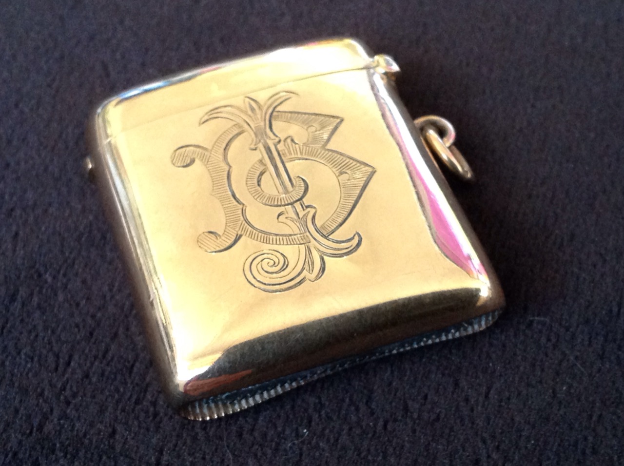 A 9ct gold vesta case with sprung hinged lid, with ring to side and striking grooved to base -