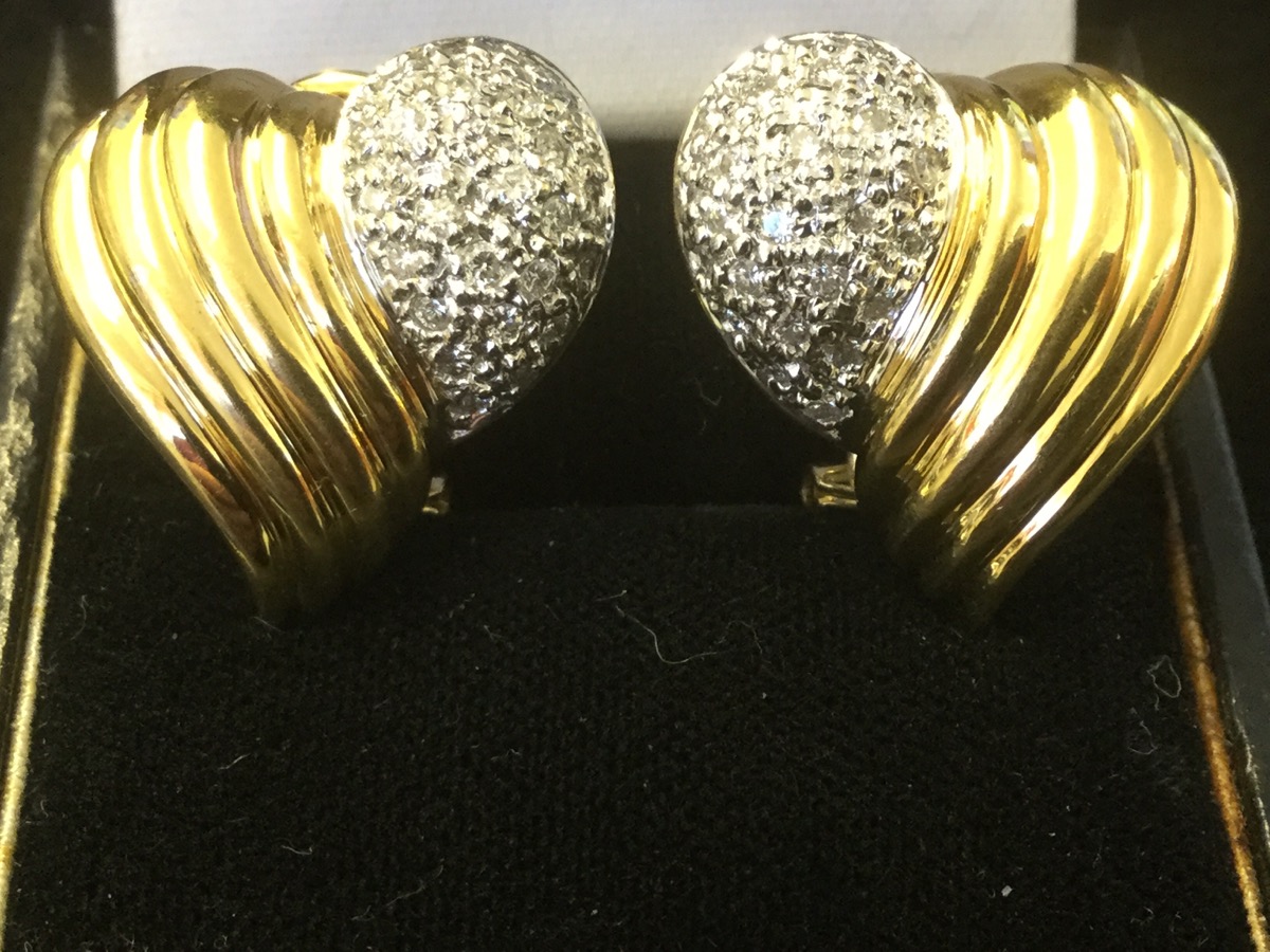 A pair of 18 carat gold heart shaped earrings, with pave set panels of diamonds bordered by fluted