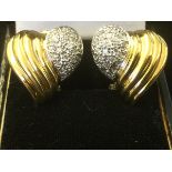 A pair of 18 carat gold heart shaped earrings, with pave set panels of diamonds bordered by fluted
