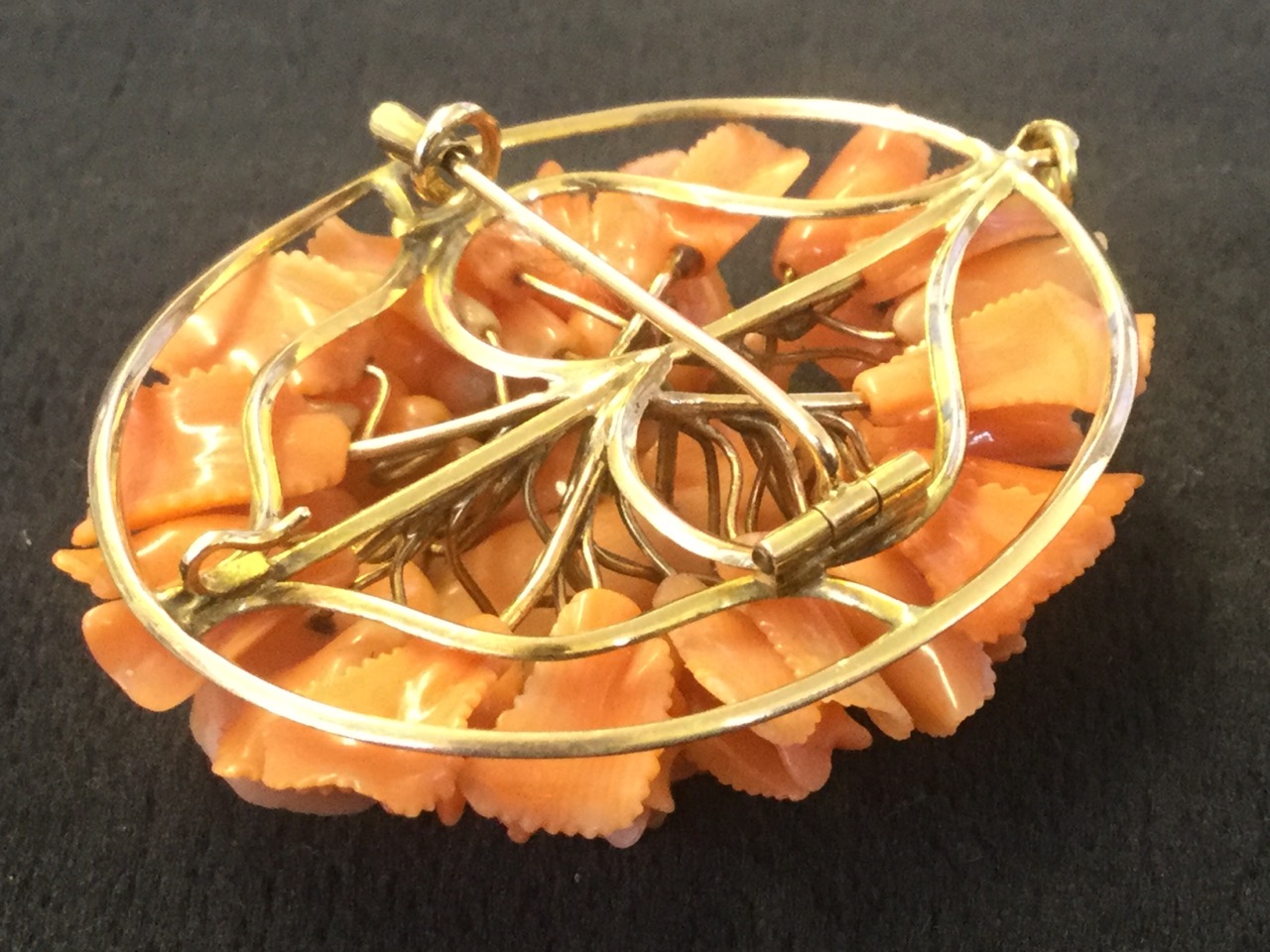 An oval carved coral brooch with cenral cherub framed by flowers and leaves, the panel mounted on - Image 3 of 3