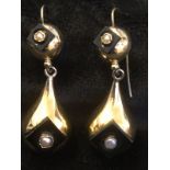 A pair of gold, onyx & pearl drop earrings, the circular domed panels and drops each set with square