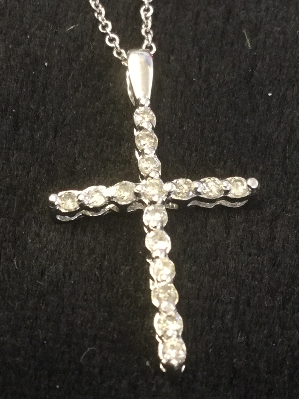 A platinum and diamond crucifix, the cross set with diamonds, mounted on a fine 18ct gold chain. (