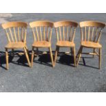 A set of four beech slatback kitchen chairs, with solid seats raised on turned legs & stretchers. (