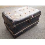 A tin trunk with carrying handles to ends, the top studded, with later black paintwork.