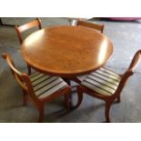 A yew wood dining table & chair set, the circular table with extending crossbanded top, supported on