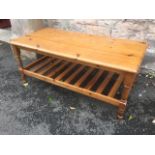 A pine coffee table, the rectangular moulded top on baluster turned legs joined by slatted