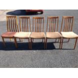 A set of four beech slatback dining chairs with upholstered seats, raised on square tapering legs;