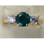 An 18ct yellow gold emerald and diamond ring, the claw set round emerald of over three-quarters of a