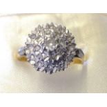 An 9ct gold cluster diamond ring, the stones set as a pyramid flowerhead flanked by two leaves,