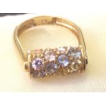 An 18ct gold revolving cubic zirconia multicoloured 'roller' ring, the yellow, blue & pink stones