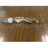 A ladies platinum ring mounted with a row of four stones; a 9ct gold ring modelled as a buckle; a