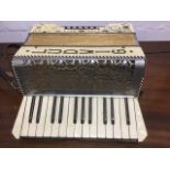 A small European accordian by Ludwig, with opalescent coloured case decorated with scrolling,