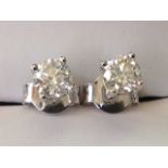 A pair of 18ct white gold diamond stud earrings, the fine claw set stones weighing over half a