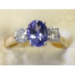 An 18ct yellow gold tanzanite & diamond three stone ring, the oval tanzanite stone weighing over a