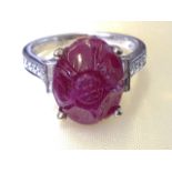 An 18ct white gold carved cabochon ruby ring, the oval claw set ruby in the form of a flower of over