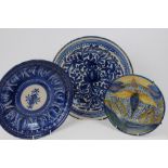 Three 19th century Delft chargers - one decorated with a chicken,