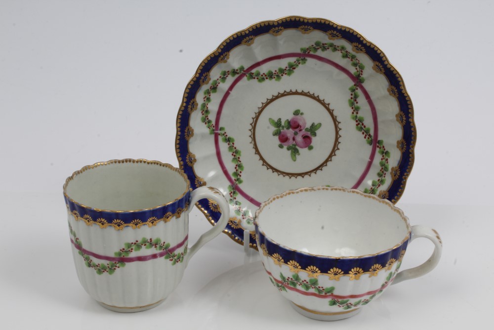 18th century Worcester fluted trio with painted garlands of flowers with blue and gilt borders -