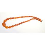 Old amber necklace with graduated oval beads, 44cm. Approximately 25.