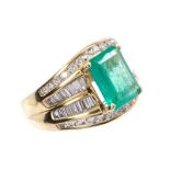 Emerald and diamond cocktail ring with a rectangular step cut emerald estimated to weigh